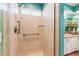 Walk-in shower with glass doors, grab bar, mosaic tile, and tiled walls at 5528 Apache Wells Way, Las Vegas, NV 89130