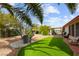 Beautiful landscaped backyard with artificial grass and mature palm trees at 5604 Ocean Pines Cir, Las Vegas, NV 89130