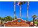 Entrance sign to Los Prados Golf Community & Country Club with palm trees and clear blue sky at 5604 Ocean Pines Cir, Las Vegas, NV 89130
