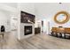 Stylish living room with a fireplace, modern flooring, an elegant mirror, and ample natural light at 5604 Ocean Pines Cir, Las Vegas, NV 89130