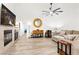 Bright open-plan living space featuring wood floors, fireplace, ceiling fan, and contemporary furnishings at 5604 Ocean Pines Cir, Las Vegas, NV 89130