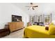 Bedroom featuring a soft yellow bedspread, wood floors, seating and a dresser with a flatscreen TV at 5604 Ocean Pines Cir, Las Vegas, NV 89130