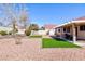 Large backyard with low-maintenance landscaping, mature trees, and a covered patio at 5927 Tropical Palm Ct, North Las Vegas, NV 89031