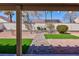 Cozy covered patio with serene backyard views, framed by desert landscaping and a pergola at 5927 Tropical Palm Ct, North Las Vegas, NV 89031