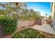 Exterior view of a backyard with a block wall, garden area, and shed at 6104 Talbot Springs Ct, North Las Vegas, NV 89081