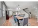 Open-concept dining area featuring hardwood floors, a large dining table, and modern lighting at 6104 Talbot Springs Ct, North Las Vegas, NV 89081
