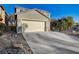 Two-story home with desert landscaping, two-car garage, and a long concrete driveway at 6104 Talbot Springs Ct, North Las Vegas, NV 89081