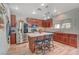 Open concept kitchen with wood cabinets, stainless steel appliances, granite countertops, and a central island with seating at 6104 Talbot Springs Ct, North Las Vegas, NV 89081