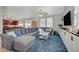 Comfortable living room features a large grey sofa, blue carpet, and a ceiling fan with light fixture at 6104 Talbot Springs Ct, North Las Vegas, NV 89081