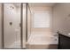 Modern bathroom featuring a glass-enclosed shower, soaking tub, and a neutral color palette at 6129 Rose Springs Ave, Las Vegas, NV 89130