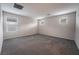 This bright bedroom features neutral walls, plush gray carpeting, and two windows for natural light at 6129 Rose Springs Ave, Las Vegas, NV 89130
