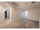 Bright bedroom featuring neutral walls, plush gray carpeting, and a window for natural light at 6129 Rose Springs Ave, Las Vegas, NV 89130