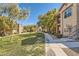 Exterior view of condominium buildings and landscaped common areas with mature trees and walking paths at 8000 Badura Ave # 1020, Las Vegas, NV 89113
