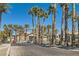 Gated entrance to the Serenade Palms Condominium Homes, lined with mature palm trees on a clear day at 8000 Badura Ave # 1020, Las Vegas, NV 89113
