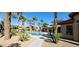 Exterior view of the community pool surrounded by mature palm trees and lounge chairs at 8000 Badura Ave # 1020, Las Vegas, NV 89113