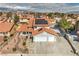 Aerial view of a home in a residential neighborhood featuring a red tile roof, solar panels, and desert landscaping at 8304 Esmont Ln, Las Vegas, NV 89117