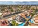 Wide aerial view featuring homes with terracotta roofs, sparkling pools and lush landscaping in a suburban community at 8304 Esmont Ln, Las Vegas, NV 89117