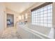 Bright bathroom features a large tub, marble floors and double vanity at 8304 Esmont Ln, Las Vegas, NV 89117