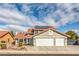 Two-story home with red tile roof, desert landscaping, three-car garage, and solar panels on the roof at 8304 Esmont Ln, Las Vegas, NV 89117