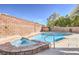 Sparkling pool and spa combo with brick trim, inviting relaxation and entertainment in the backyard at 8304 Esmont Ln, Las Vegas, NV 89117