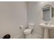 Clean half-bathroom with a pedestal sink, decorative mirror, and neutral color palette with tiled flooring at 864 Klamath Springs St, Henderson, NV 89011