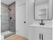 Updated bathroom with gray tiled shower and modern vanity featuring black hardware at 909 Hazard Ave, Las Vegas, NV 89108