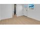 Bright bedroom with hardwood floors, white walls, and a door leading to a bathroom at 909 Hazard Ave, Las Vegas, NV 89108