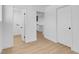 Hallway with light hardwood floors, neutral paint, and doors leading to a bathroom and the kitchen at 909 Hazard Ave, Las Vegas, NV 89108