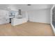 Open-concept living space with modern kitchen, island, and light hardwood floors at 909 Hazard Ave, Las Vegas, NV 89108