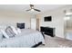 Comfortable bedroom features bed, dressers, mounted TV and entrance to bathroom at 9675 Bold Skye Ave, Las Vegas, NV 89166