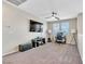 Comfortable living room area featuring a TV, work station, and carpet flooring at 9675 Bold Skye Ave, Las Vegas, NV 89166