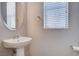Half bath features a pedestal sink and a window with blinds at 10429 Amber Night St, Las Vegas, NV 89183