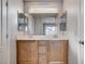 Bathroom featuring dual sinks, wooden cabinetry, and a large, well-lit mirror at 10429 Amber Night St, Las Vegas, NV 89183