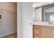 Bright bathroom with wooden cabinets, dual sinks, and access to a closet at 10429 Amber Night St, Las Vegas, NV 89183