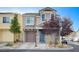 Charming two-story home featuring desert landscaping, a brown garage door, and a welcoming blue front door at 10429 Amber Night St, Las Vegas, NV 89183