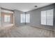 Spacious living room filled with natural light from two large windows, carpet flooring, and neutral paint at 10429 Amber Night St, Las Vegas, NV 89183