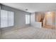 Spacious living room featuring neutral paint and flooring with a staircase and many windows at 10429 Amber Night St, Las Vegas, NV 89183