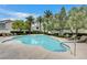 Community pool with lounge chairs and lush landscaping at 10429 Amber Night St, Las Vegas, NV 89183
