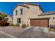 Two-story home boasts a brown two-car garage, stucco exterior, and a brick paver driveway for added curb appeal at 1055 Admiral Emblem St, Henderson, NV 89015