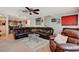 Open-concept living room features a modern ceiling fan, an oversized leather sofa, and carpeted flooring at 1055 Admiral Emblem St, Henderson, NV 89015