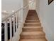 A carpeted staircase with white railing leads to the upper level of this lovely home at 1055 Admiral Emblem St, Henderson, NV 89015