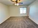 Bedroom featuring neutral carpeting, a ceiling fan, and a window for natural light at 10715 York Manor Ave, Las Vegas, NV 89166
