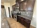 Kitchen with stainless steel appliances, dark cabinets, granite countertops, and mosaic backsplash at 10715 York Manor Ave, Las Vegas, NV 89166
