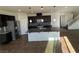 Kitchen with stainless steel appliances, a central island, dark cabinets, and granite countertops at 10715 York Manor Ave, Las Vegas, NV 89166