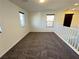 Upstairs loft with cozy carpeting and natural light from the windows at 10715 York Manor Ave, Las Vegas, NV 89166