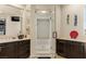 Bathroom featuring dual sinks, vanity, walk-in shower with glass doors, and dark wood cabinets at 11241 Golden Chestnut Pl, Las Vegas, NV 89135