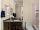 Bathroom with granite countertops, brown cabinets, toilet, shower and decorative mirror at 11241 Golden Chestnut Pl, Las Vegas, NV 89135