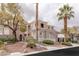 Elegant two-story home featuring a stucco exterior, lush landscaping, and mature palm trees at 11241 Golden Chestnut Pl, Las Vegas, NV 89135