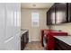 Laundry room with red washer and dryer units, sink, cabinets, and ample counter space at 11241 Golden Chestnut Pl, Las Vegas, NV 89135