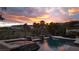 Inviting pool with water features, set against a backdrop of a vibrant sunset and palm trees at 11241 Golden Chestnut Pl, Las Vegas, NV 89135